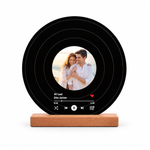 Schwarzer personalisierter Fotoaufsteller im Schallplatten-Design mit rundem Paarfoto als Gestaltungsbeispiel auf weißem Hintergrund.
